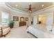 Tranquil main bedroom featuring a ceiling fan, plush carpet, and an ensuite bathroom for added privacy at 13214 Treviso Dr, Bradenton, FL 34211