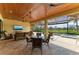 Beautiful, covered outdoor patio with seating area and view of pool and landscaped backyard at 13214 Treviso Dr, Bradenton, FL 34211