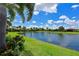 Scenic view of a tranquil pond surrounded by lush greenery and blue skies at 13214 Treviso Dr, Bradenton, FL 34211