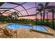 Sparkling pool and spa inside screened lanai, offering views of the picturesque landscaping and sunset at 13214 Treviso Dr, Bradenton, FL 34211