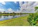 Relaxing view of the backyard from the green lawn to the lake water and the rest of the community at 13214 Treviso Dr, Bradenton, FL 34211