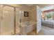 Bathroom showcasing shower with glass door, soaking tub and access to main bedroom at 1345 Burgos Dr # 101, Sarasota, FL 34238