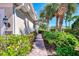 Beautiful home exterior with lush landscaping along the brick walkway and well-manicured lawn at 1345 Burgos Dr # 101, Sarasota, FL 34238