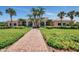 Exterior of clubhouse with brick walkway, lush green landscaping, and arched windows offering scenic views at 1345 Burgos Dr # 101, Sarasota, FL 34238