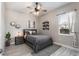 Cozy bedroom with a ceiling fan, stylish decor, a gray rug, and a well-lit window at 14540 Gaspar Loop, Port Charlotte, FL 33981