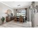 Dining room with a rustic wood table, modern chandelier, neutral colors, and sliding glass doors to the outside at 14540 Gaspar Loop, Port Charlotte, FL 33981