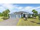Charming single-Gathering home featuring a three-car garage, stone driveway, and well-manicured lawn at 14540 Gaspar Loop, Port Charlotte, FL 33981