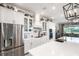 Modern kitchen features stainless steel appliances, white cabinetry, island with sink, and stylish lighting fixtures at 14540 Gaspar Loop, Port Charlotte, FL 33981