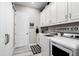 Well-organized laundry room with white cabinets, modern appliances, and stylish black and white accents at 14540 Gaspar Loop, Port Charlotte, FL 33981