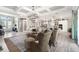 Bright, open-concept living room with coffered ceilings, chandelier, and seamless flow to kitchen with white cabinets at 14540 Gaspar Loop, Port Charlotte, FL 33981