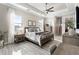 Well-lit main bedroom with tray ceilings, neutral colors, and wood-look tile flooring at 14540 Gaspar Loop, Port Charlotte, FL 33981