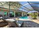 An outdoor bar area overlooks a screened-in pool, creating a perfect setting for entertaining and relaxation at 14540 Gaspar Loop, Port Charlotte, FL 33981