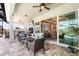 Relaxing outdoor patio with wicker furniture, a ceiling fan, and large sliding glass doors at 14540 Gaspar Loop, Port Charlotte, FL 33981