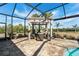A covered pergola offers shade and seating by the pool, with views of the expansive outdoor area at 14540 Gaspar Loop, Port Charlotte, FL 33981
