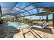 Screened-in pool and patio area with plenty of space for lounging and entertaining, set against a lush backyard at 14540 Gaspar Loop, Port Charlotte, FL 33981