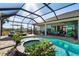 Beautiful screened-in pool area with a jacuzzi, lounge chairs, and an outdoor bar for entertaining at 14540 Gaspar Loop, Port Charlotte, FL 33981