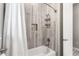 Close-up view of a tiled bathtub and shower with built-in niche, sleek hardware, and a shower curtain at 14540 Gaspar Loop, Port Charlotte, FL 33981
