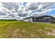 Backyard view featuring a screened in porch, lush green lawn and a white picket fence at 15890 County Road 675, Parrish, FL 34219