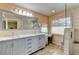 Modern bathroom featuring a double sink vanity, walk-in shower, and wood-look tile flooring at 15890 County Road 675, Parrish, FL 34219