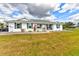 Charming single-story home features a well-manicured lawn and freshly painted white exterior at 15890 County Road 675, Parrish, FL 34219