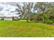 Lush green lawn featuring a large metal barn and mature trees at 15890 County Road 675, Parrish, FL 34219