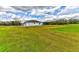 Beautiful exterior view of the home featuring solar panels, sprawling yard, and fenced perimeter at 15890 County Road 675, Parrish, FL 34219