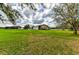 Wide green lawn showcases a metal barn, house, and white fencing at 15890 County Road 675, Parrish, FL 34219