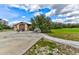 Spacious property featuring a large barn with roll-up doors, concrete driveway, and lush green space at 15890 County Road 675, Parrish, FL 34219