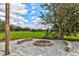 Inviting outdoor fire pit and seating area surrounded by lush greenery and blue sky at 15890 County Road 675, Parrish, FL 34219