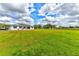 Sprawling front lawn showcasing the house with a lovely white fence line and garages to the left at 15890 County Road 675, Parrish, FL 34219
