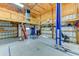 Spacious garage featuring a car lift, work area, insulated walls and ample storage space at 15890 County Road 675, Parrish, FL 34219