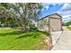 Side view of detached garage, showcasing additional parking with mature landscaping and well-maintained grounds at 15890 County Road 675, Parrish, FL 34219