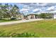 Exterior shot of multiple garages with parking for multiple cars and RVs, surrounded by a well-maintained yard at 15890 County Road 675, Parrish, FL 34219
