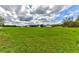 Expansive green field showcasing the home, screened in porch and large lot with a white fence at 15890 County Road 675, Parrish, FL 34219