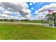 Scenic property view featuring a lush green lawn, serene pond with fountain, and an American flag at 15890 County Road 675, Parrish, FL 34219