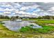 Picturesque pond with fountain and lush greenery, surrounded by a white fence and a charming home at 15890 County Road 675, Parrish, FL 34219