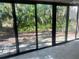 Bright Florida room with full wall of sliding glass doors overlooking lush greenery at 1697 Brookhouse Cir # 116, Sarasota, FL 34231