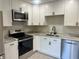 Modern kitchen featuring stainless steel appliances, white cabinetry, and stone countertops at 1697 Brookhouse Cir # 116, Sarasota, FL 34231