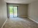Neutral living room featuring tiled floor and sliding doors to the outdoor patio with treed views at 1697 Brookhouse Cir # 116, Sarasota, FL 34231
