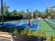 Several pickleball courts on a sunny day surrounded by trees at 1697 Brookhouse Cir # 116, Sarasota, FL 34231