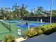 Several pickleball courts on a sunny day surrounded by trees at 1697 Brookhouse Cir # 116, Sarasota, FL 34231