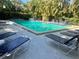 Beautiful community pool surrounded by lounge chairs and tropical trees at 1697 Brookhouse Cir # 116, Sarasota, FL 34231
