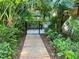 Gated pool access surrounded by tropical vegetation at 1697 Brookhouse Cir # 116, Sarasota, FL 34231