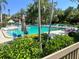 Community pool surrounded by lush landscaping and lounge chairs for relaxation at 1697 Brookhouse Cir # 116, Sarasota, FL 34231