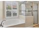 Bathroom featuring a soaking tub, glass shower, and plantation shutters at 1720 85Th Nw Ct, Bradenton, FL 34209