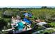 Community pool with blue awnings, lounge chairs, and a playground surrounded by palm trees at 1720 85Th Nw Ct, Bradenton, FL 34209