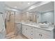 Bright bathroom featuring white cabinets, a vessel sink, neutral tile and a glass-enclosed shower stall at 1771 Ringling Blvd # 1001, Sarasota, FL 34236