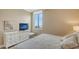 Comfortable bedroom with a large window with ocean view, dresser and television at 1945 Gulf Of Mexico Dr # M2-516, Longboat Key, FL 34228
