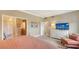 Bright bedroom featuring a TV, dresser, closet, and ensuite bathroom at 1945 Gulf Of Mexico Dr # M2-516, Longboat Key, FL 34228