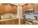 Kitchen with light wood cabinets, stainless steel appliances, and tile backsplash at 1945 Gulf Of Mexico Dr # M2-516, Longboat Key, FL 34228